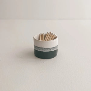 Black grey and white small ceramic match pot filled with white tipped matches